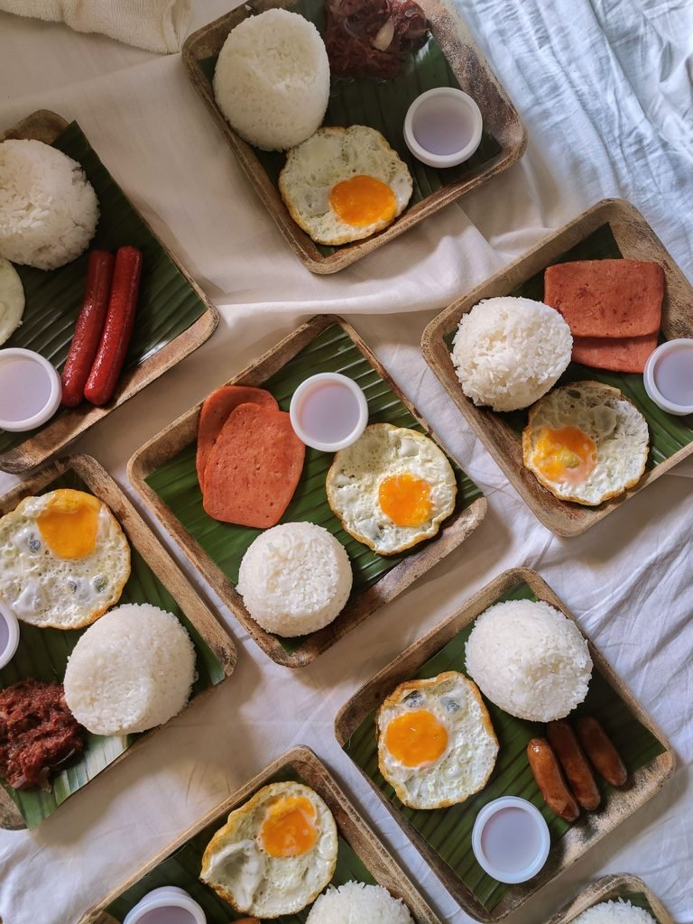 A Filipino silog meal with fried rice, egg, and a savory meat dish on a plate.