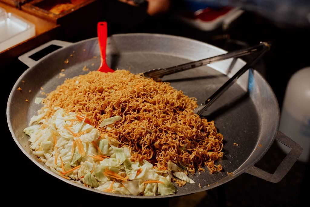 A serving of stir-fried Canton noodles in a bowl.