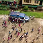Aerial view of a school with people gathered around the campus.