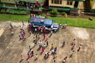 Aerial view of a school with people gathered around the campus.