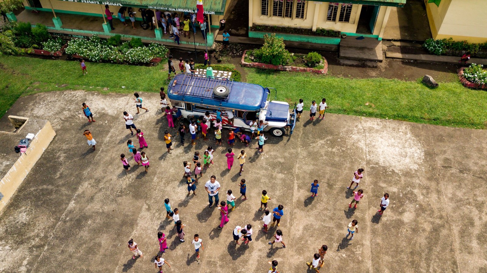 Aerial view of a school with people gathered around the campus.