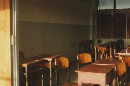 An empty classroom with sunlight streaming through the windows.