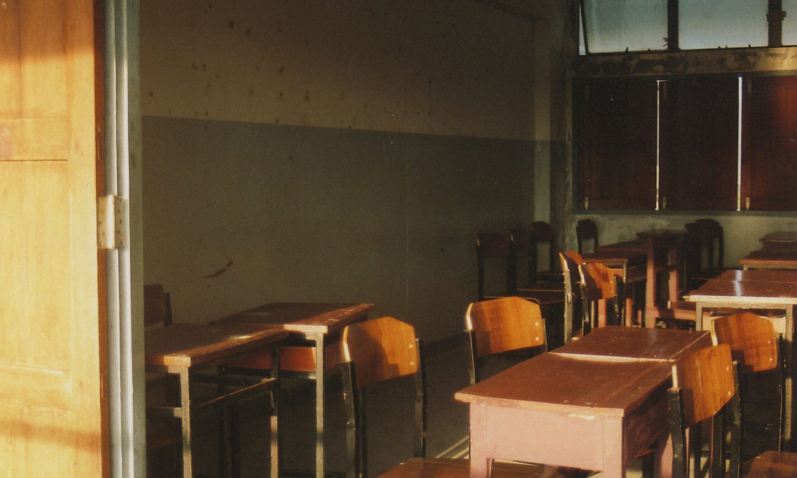 An empty classroom with sunlight streaming through the windows.