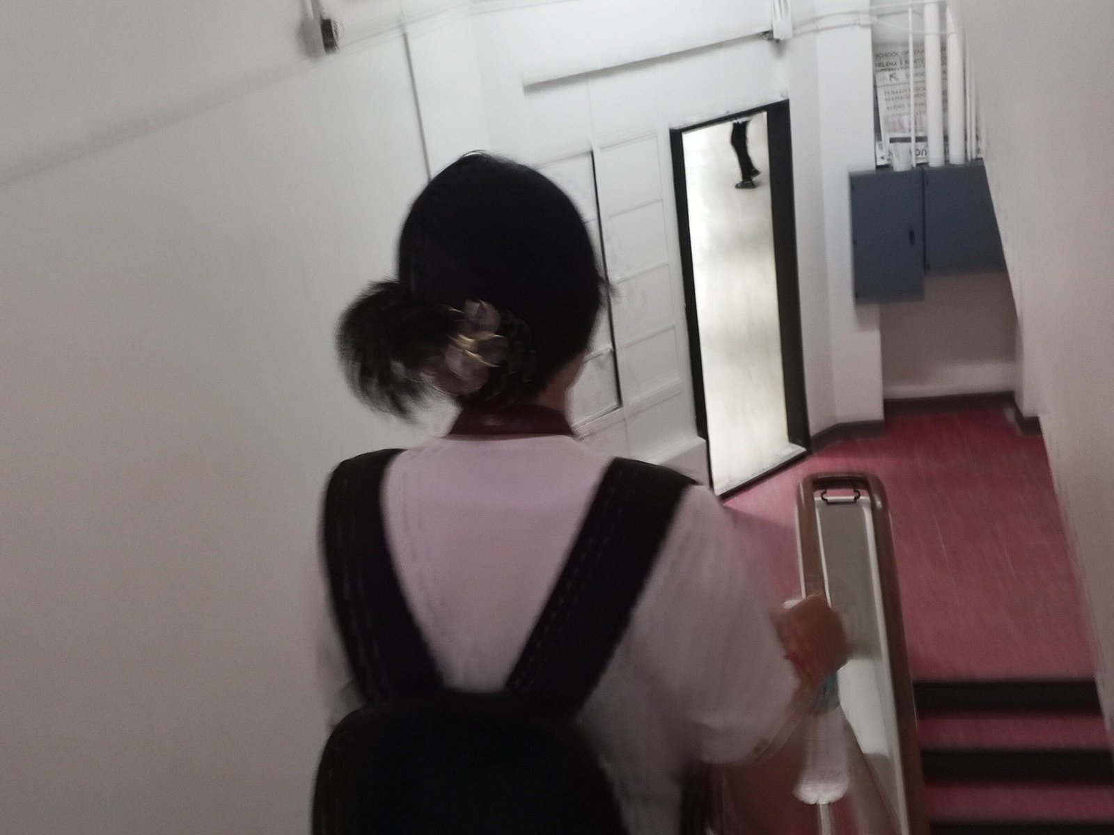 student walks down the stairs of the Taft Wing building at Philippine Women’s University.
